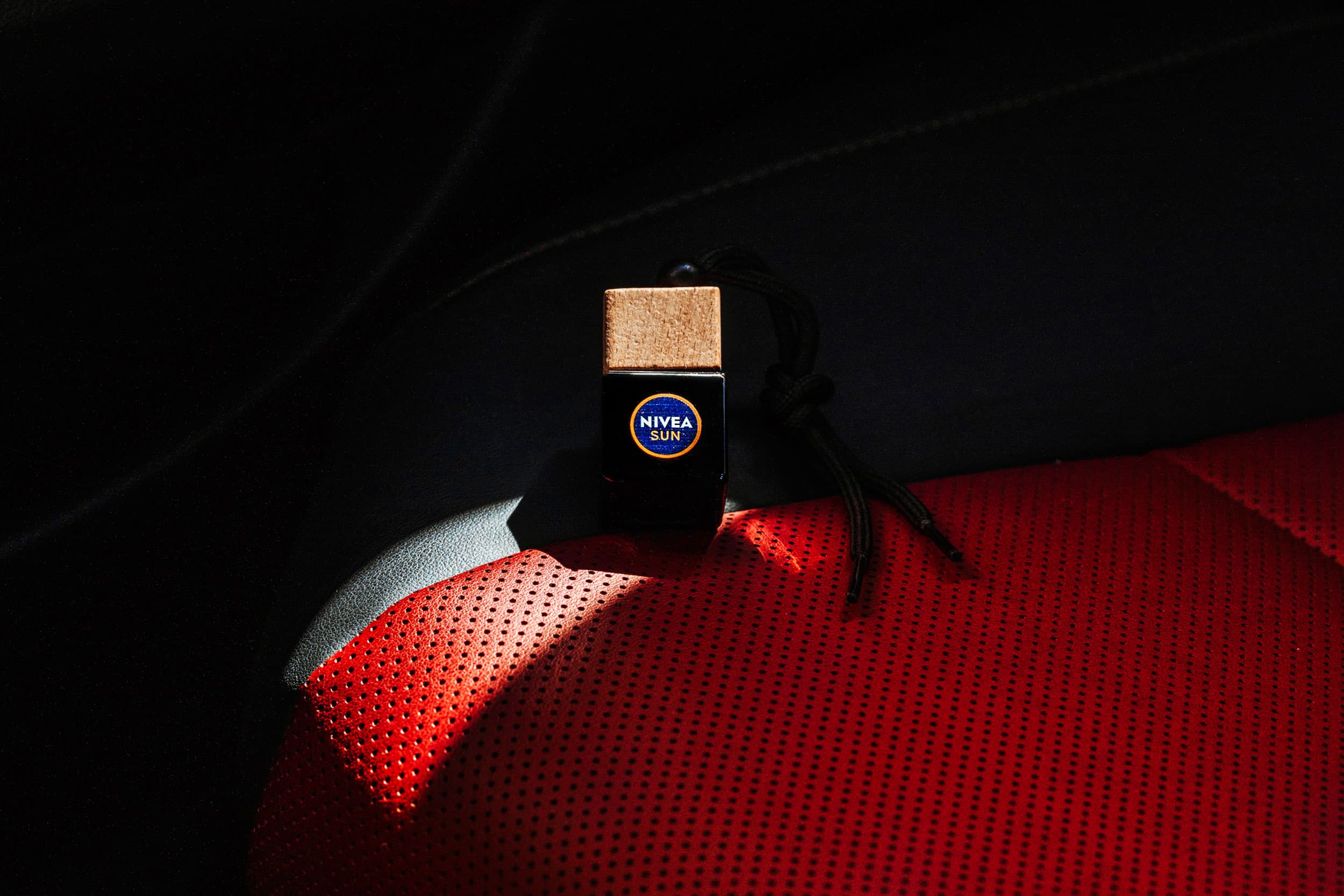 Parfum auto personalizat, suspendat într-un interior auto.